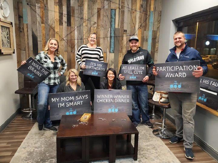A group at The Pod holding playful victory signs in the lobby